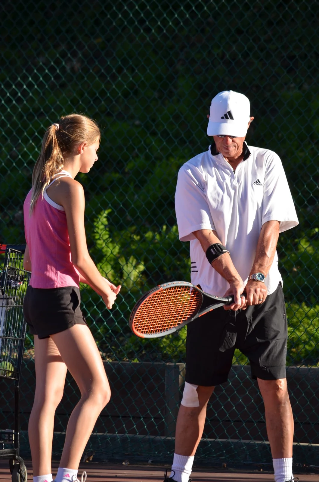 Coach Thor Schreck demonstrating tennis technique during a lesson in Concord, California